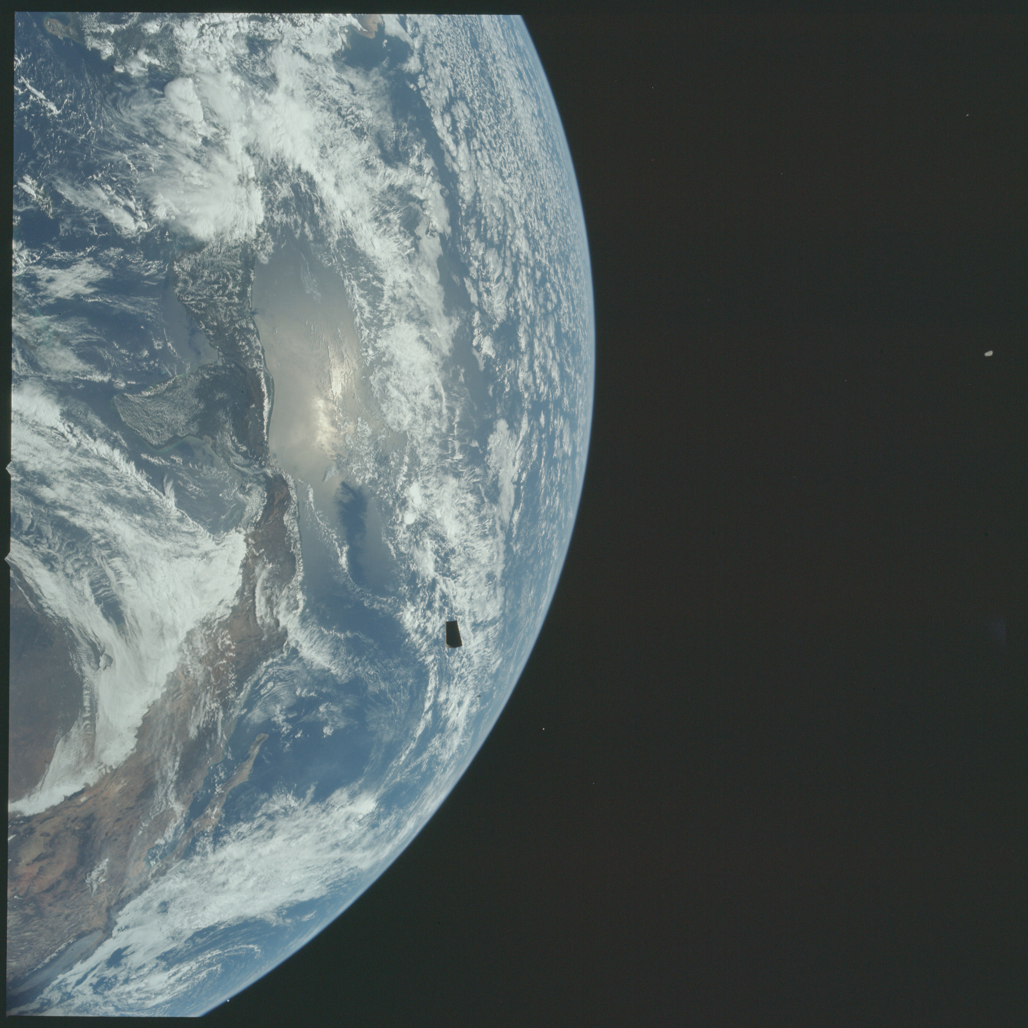 Fotografia Ziemi wykonana podczas misji Apollo 12. Na tle planety możemy zaobserwować jeden z czterech paneli adaptera odrzucanych podczas transpozycji i dokowania. 
